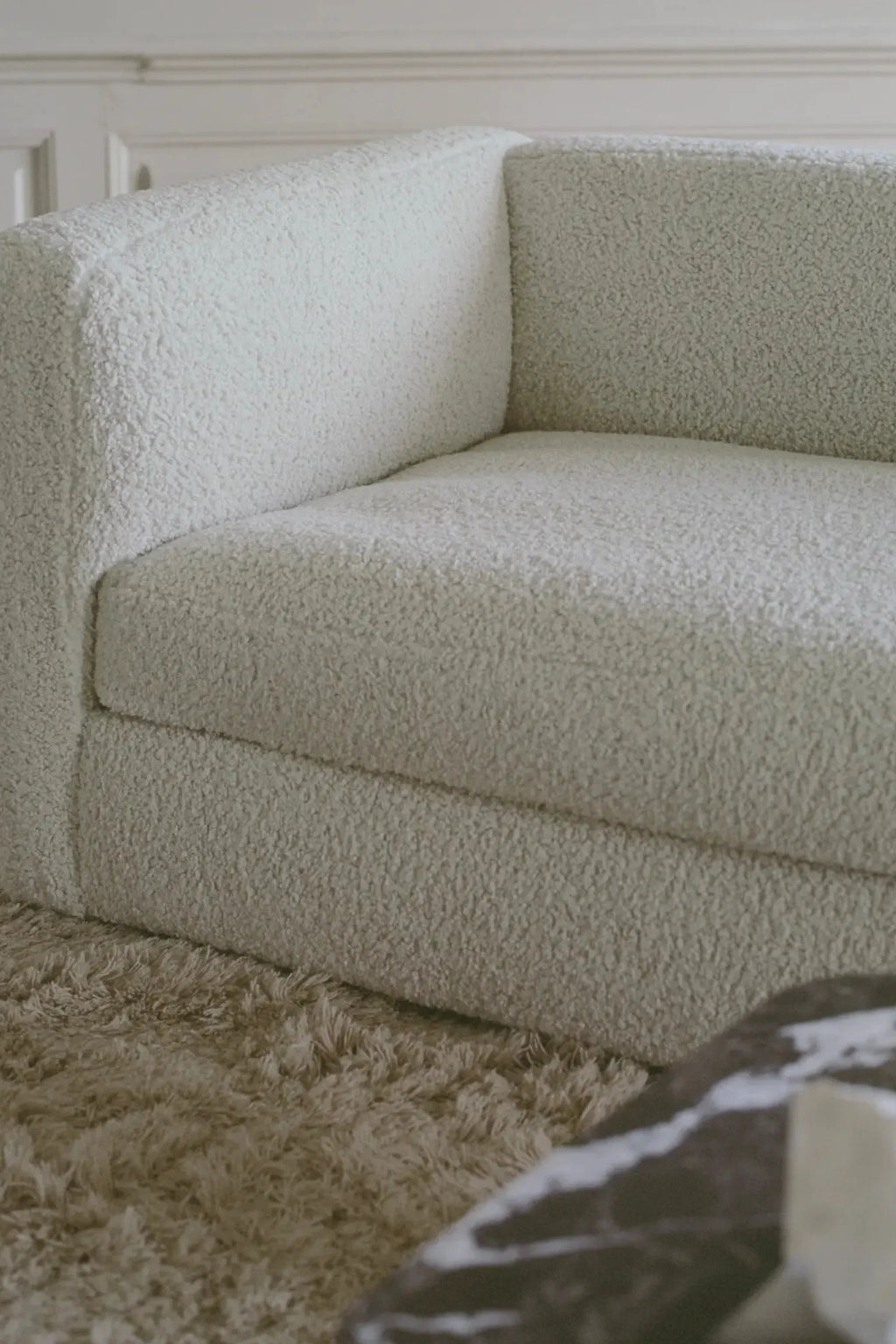 New Works Coda 3-Seater Sofa Configuration 4, a contemporary modular sofa upholstered in a plush cream bouclé fabric with a highly textured, soft feel and clean, boxy silhouette. This off-white deep seating sofa offers an inviting, organic modern aesthetic. Ideal for minimalist or Scandinavian living rooms seeking comfort and style.