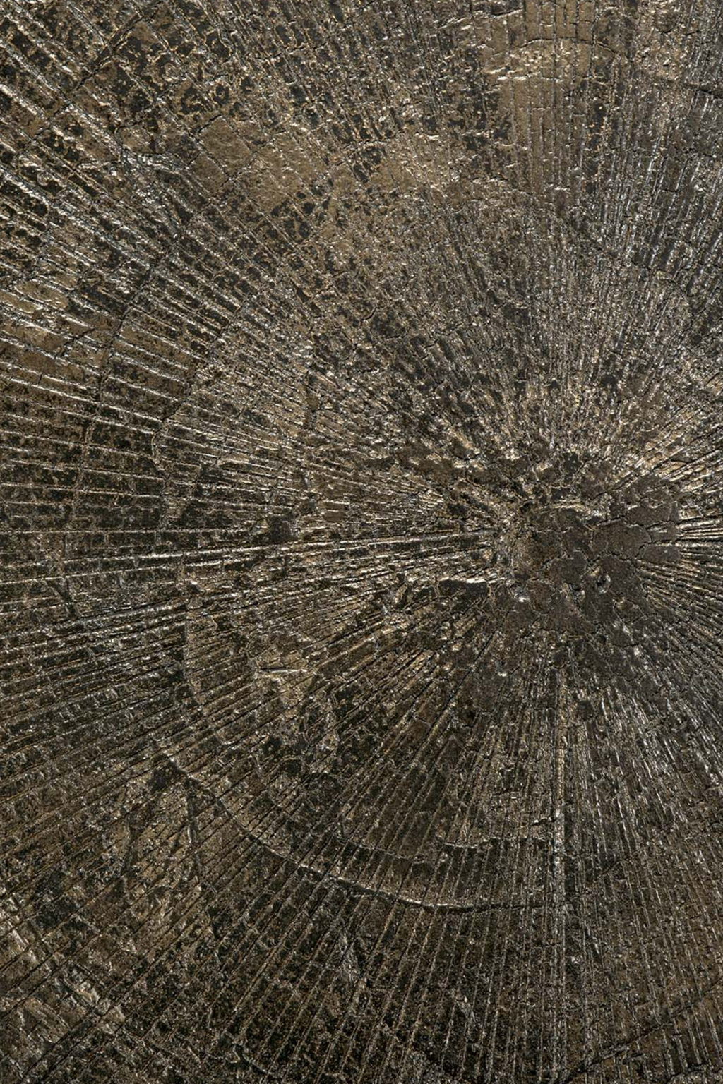 Ethnicraft Blend Round Dining Table, a striking dark wood dining table featuring a deeply textured surface with a radial, tree-ring-inspired pattern and a metallic bronze finish. Its unique, raw aesthetic combines organic modern and industrial chic styles, evoking a sense of natural brutalism. Perfect as a statement piece for contemporary dining rooms or design-conscious living spaces.