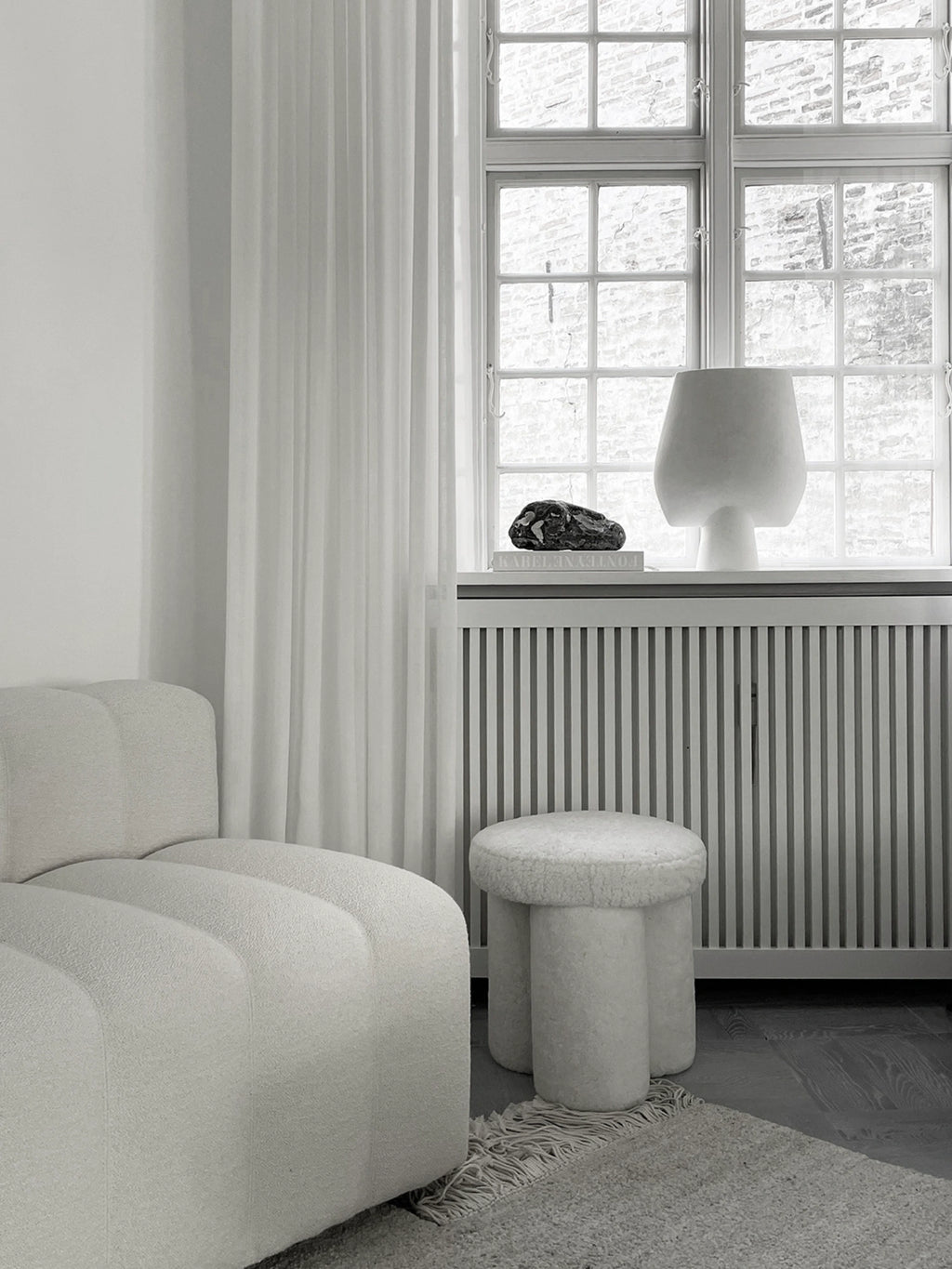 101 CPH Big Foot Stool, elegant white bouclé stool with a thick, plush round top and three stout, cylindrical legs, offering a modern, minimalist design. Perfect as stylish extra seating or a decorative accent for sophisticated living spaces.