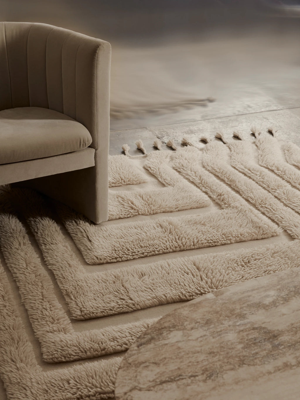Tinted Objects Kask Wool Rug, a luxurious cream-colored wool area rug featuring a plush, high-pile geometric pattern with subtle tassels. This premium floor covering is ideal for adding warmth and texture to a modern living room or bedroom for discerning homeowners.