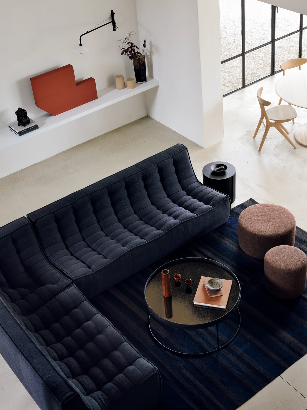 Ethnicraft Barrow Pouf, a round contemporary pouf upholstered in a warm, textured terracotta-toned fabric, featuring a soft, inviting surface and a sturdy cylindrical shape. This organic modern ottoman provides comfortable extra seating or a stylish footrest, perfect for living room accent styling or a cozy bedroom addition.