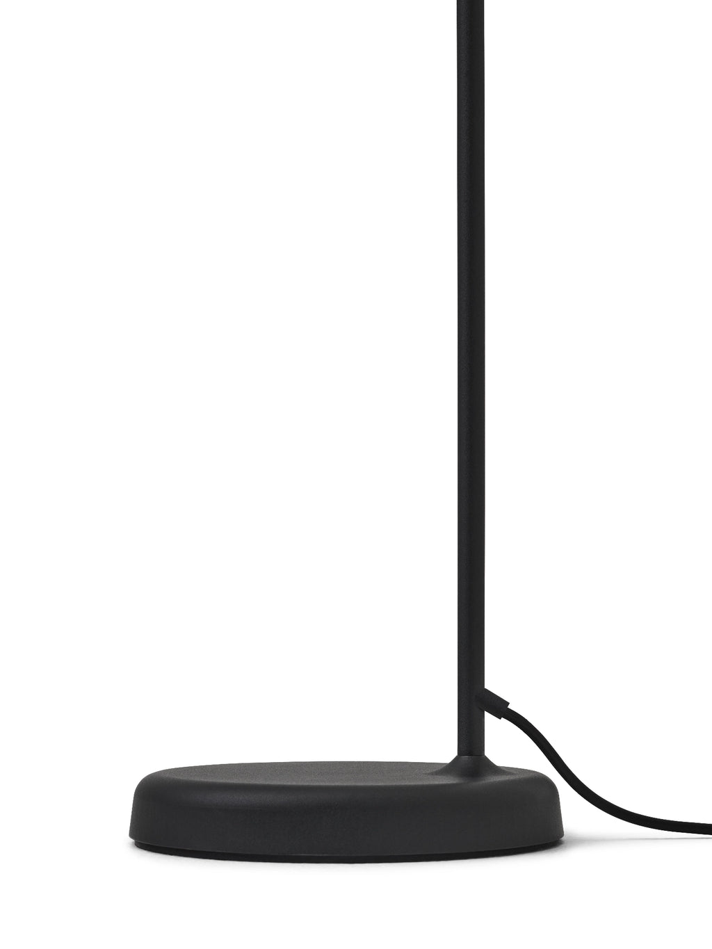 New Works Material Floor Lamp, a sleek modern minimalist floor lamp featuring a matte black metal finish with a round, subtly domed base and a slender cylindrical stem. This contemporary Scandinavian lighting piece is perfect for adding functional and stylish ambient light to a living room, bedroom, or reading nook.