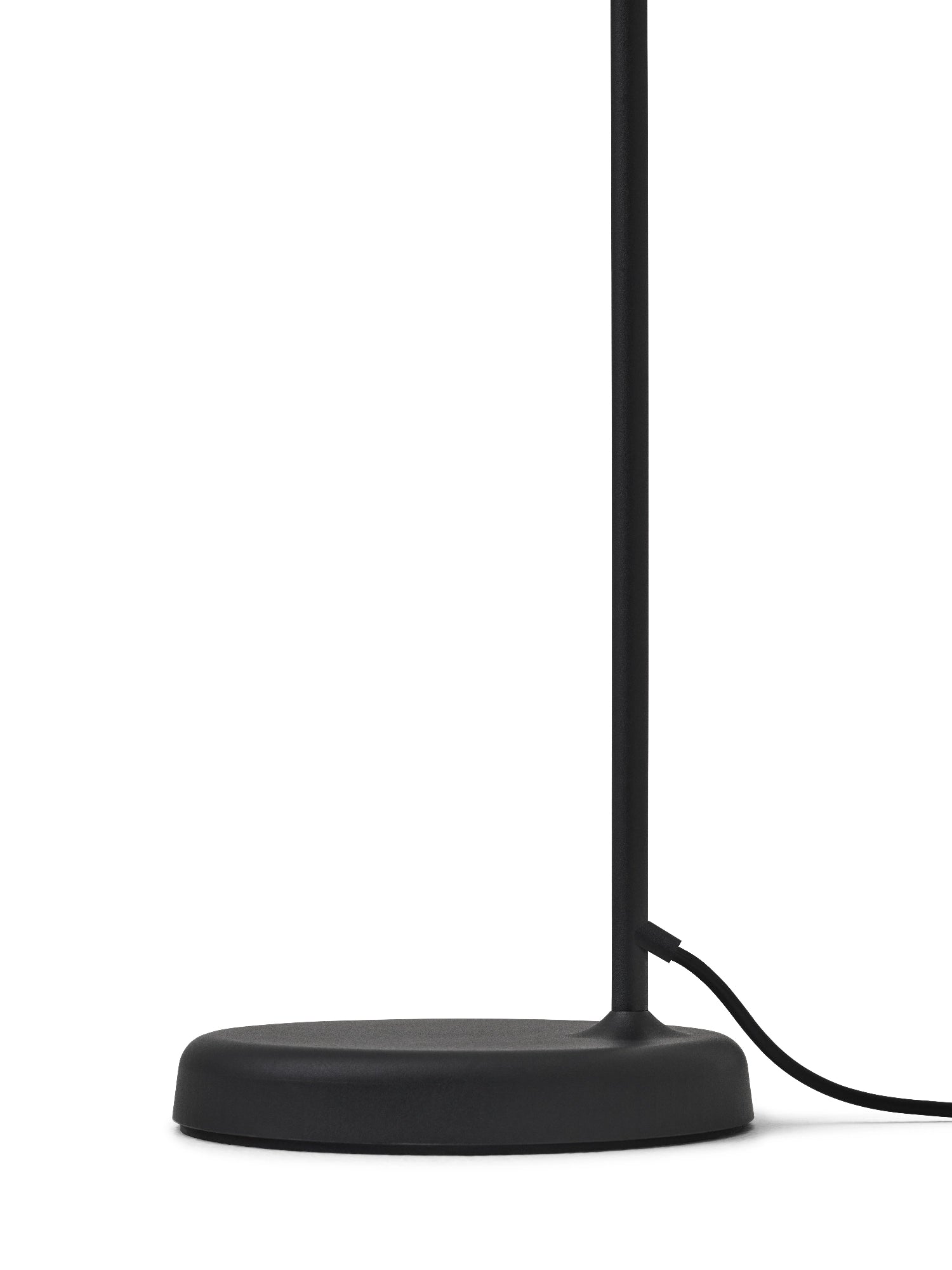 New Works Material Floor Lamp, a sleek modern minimalist floor lamp featuring a matte black metal finish with a round, subtly domed base and a slender cylindrical stem. This contemporary Scandinavian lighting piece is perfect for adding functional and stylish ambient light to a living room, bedroom, or reading nook.
