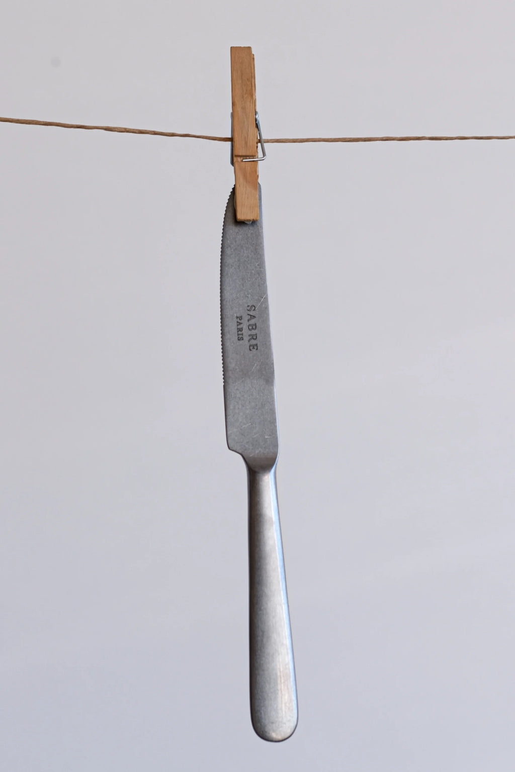 Sabre Paris Marius 5-Piece Cutlery Flatware Set, featuring a single knife with a brushed stainless steel blade and handle, displaying the "SABRE PARIS" logo. This elegant, durable flatware is perfect for modern dining, enhancing any mealtime experience for discerning hosts.