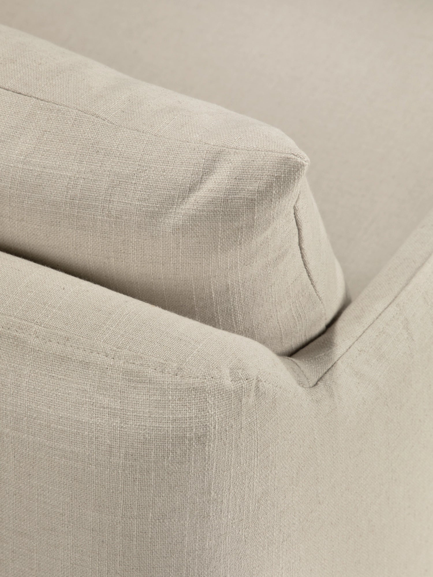 Ethnicraft Weave Lounge Chair, a close-up of a plush, natural beige lounge chair upholstered in a textured linen-blend fabric. It features soft, inviting cushions with subtle piping details, showcasing an organic modern aesthetic. Perfect as a comfortable accent chair for contemporary living rooms, minimalist bedrooms, or cozy reading nooks.