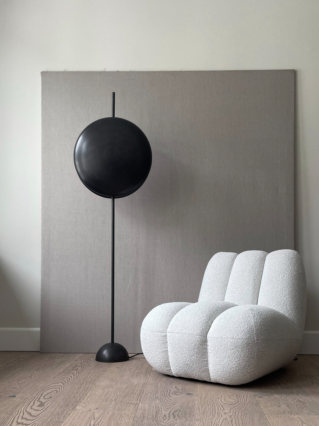 101 CPH Totem Floor Lamp with a large, dark bronze circular shade and slender support pole on a round base, displayed in a modern interior with wooden floors. This luxury lighting piece offers ambient illumination.