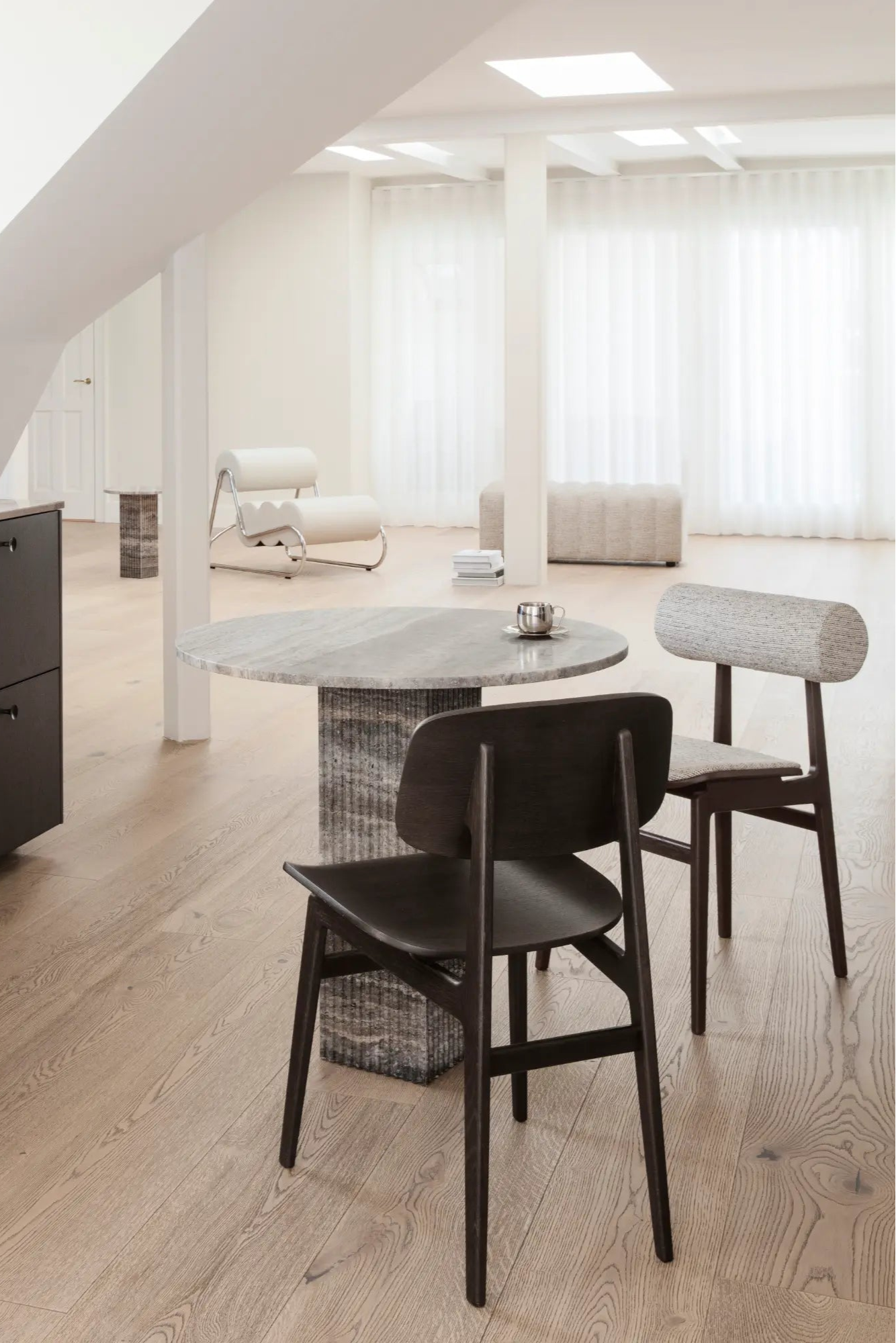 A modern, sleek and comfortable black leather totem chair with wooden legs