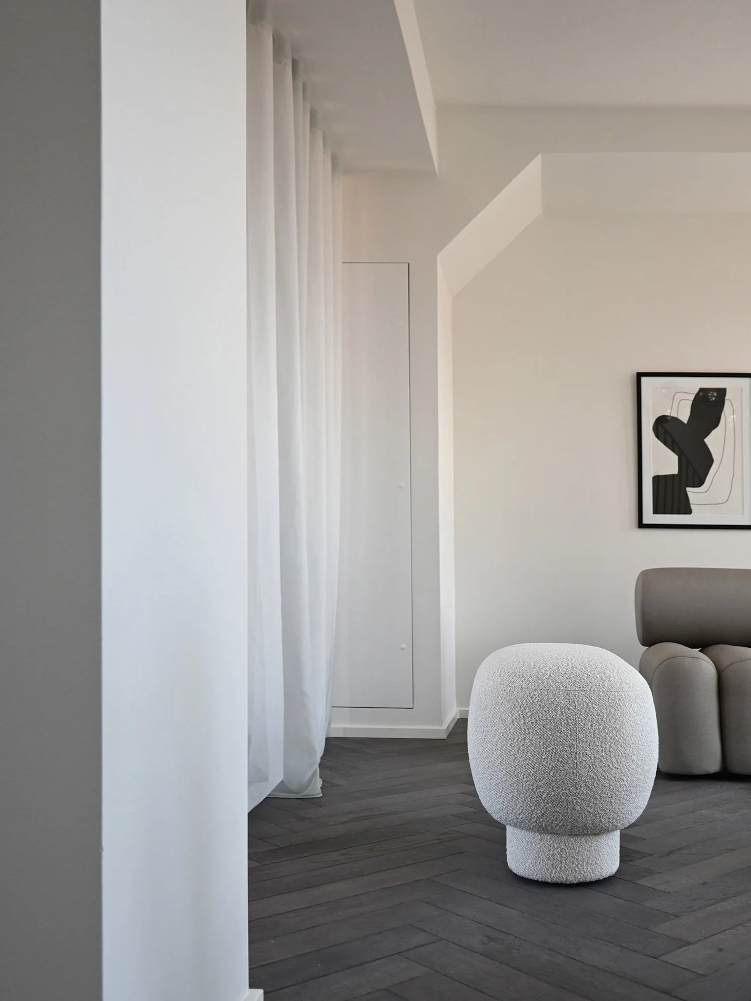 101 CPH Petit Big Foot Bench - Boucle in a lifestyle shot. This premium, light grey textured boucle bench features an organic, mushroom-like shape on dark herringbone flooring. Perfect for modern interior styling.