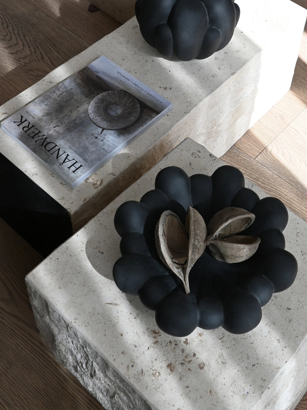 101 CPH Bloom Tray in matte black ceramic, featuring a distinctive organic, scalloped design, styled on a stone table with dried botanicals. This authentic sculptural tray is ideal for decorative display.