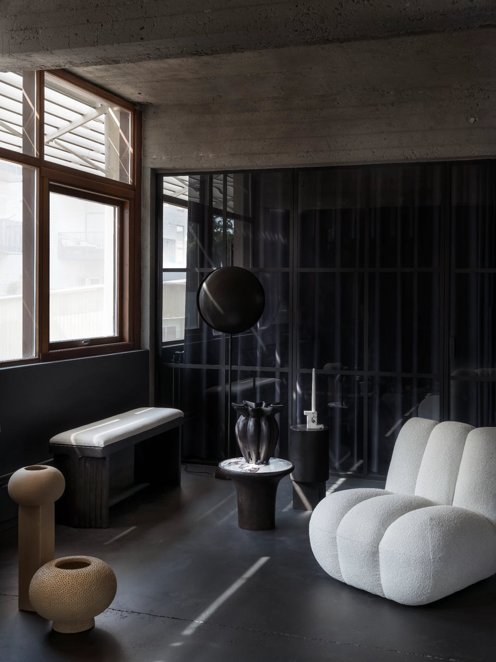 101 CPH Kabin Vase - Shisen. A sculptural, dark bronze-toned ceramic vase with a textured, fluted body, placed on a modern side table in a luxury living room. Perfect for contemporary decor.