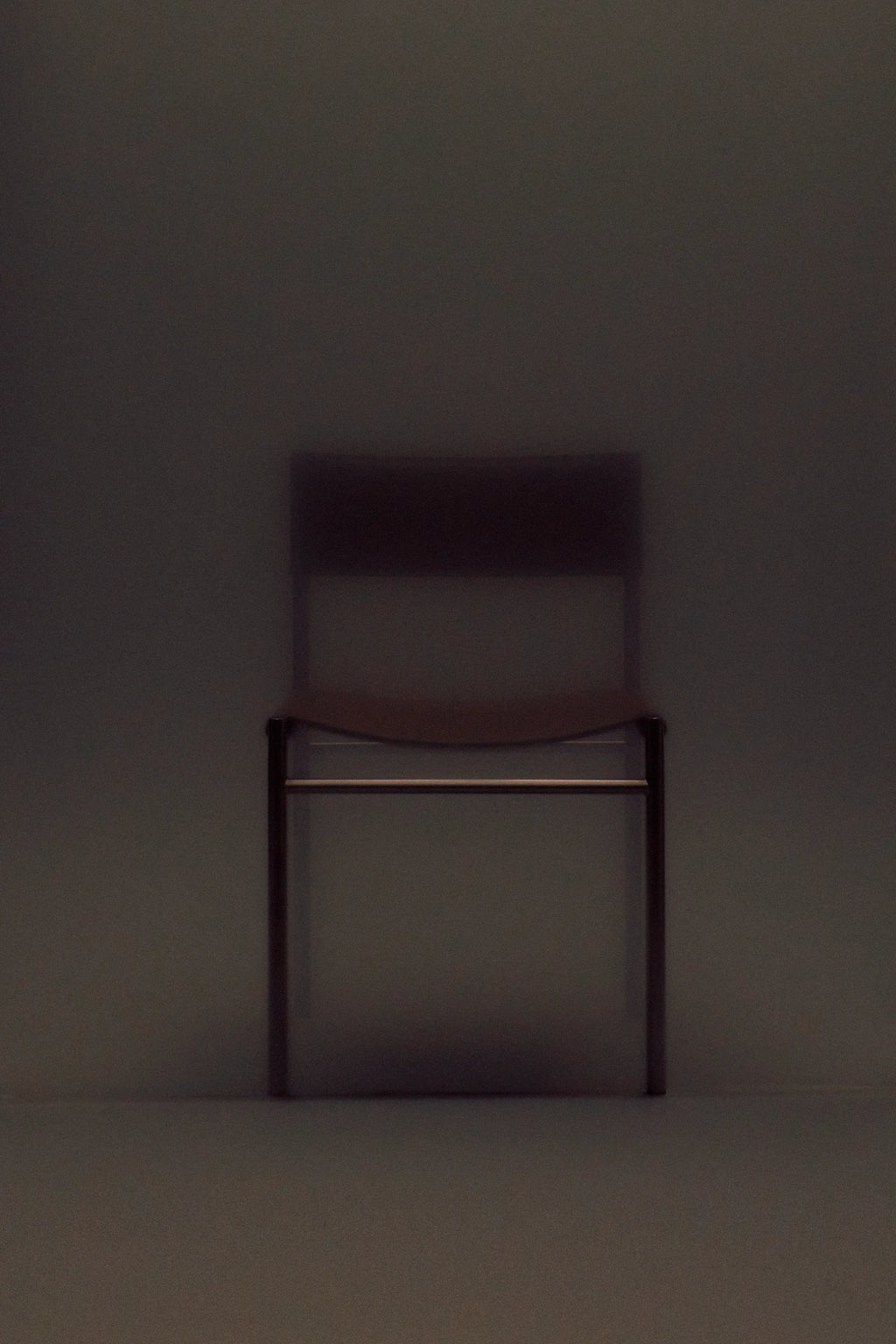 Dark brown chair against a matching dark background