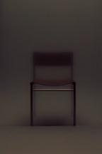 Dark brown chair against a matching dark background