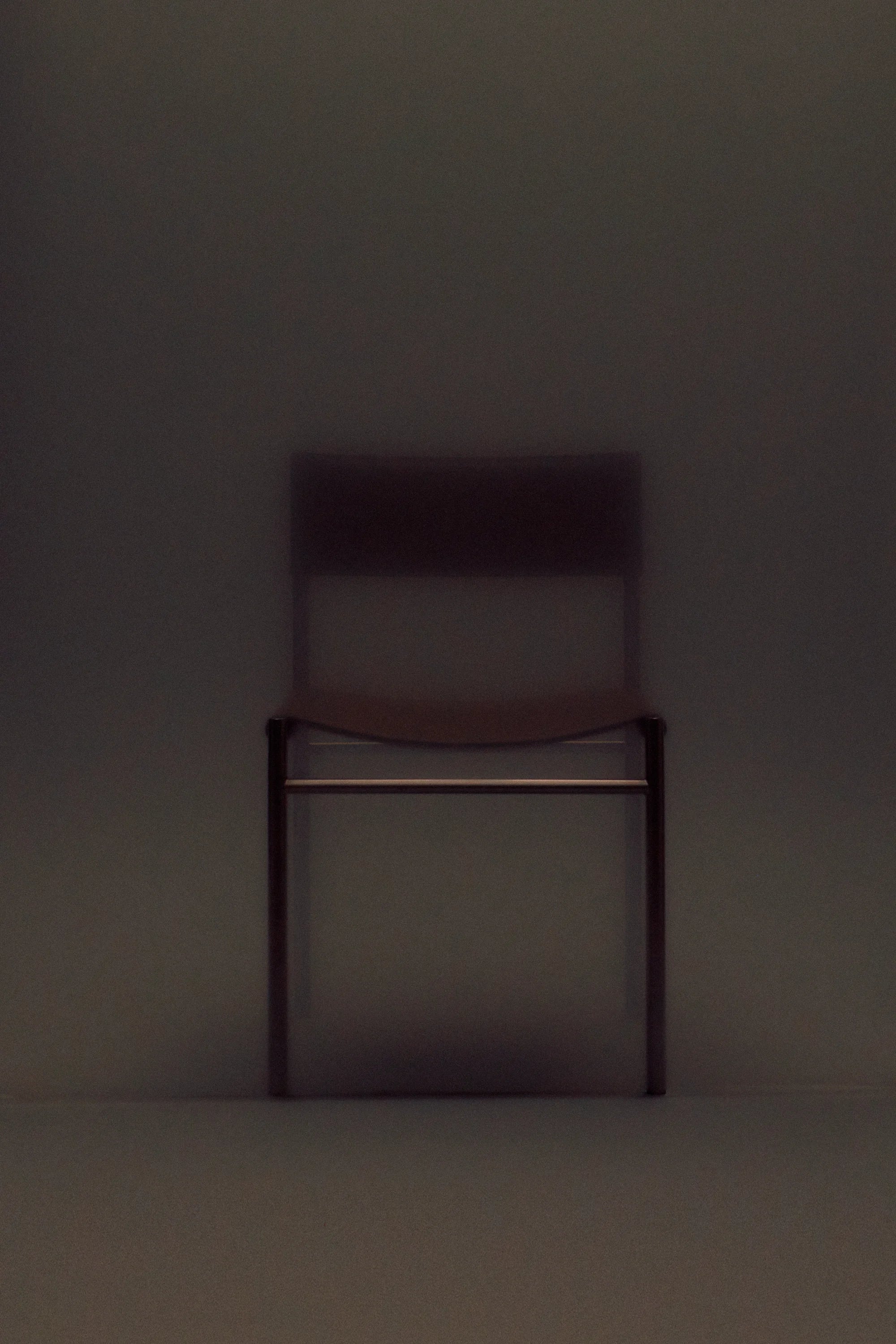 Dark brown chair against a matching dark background