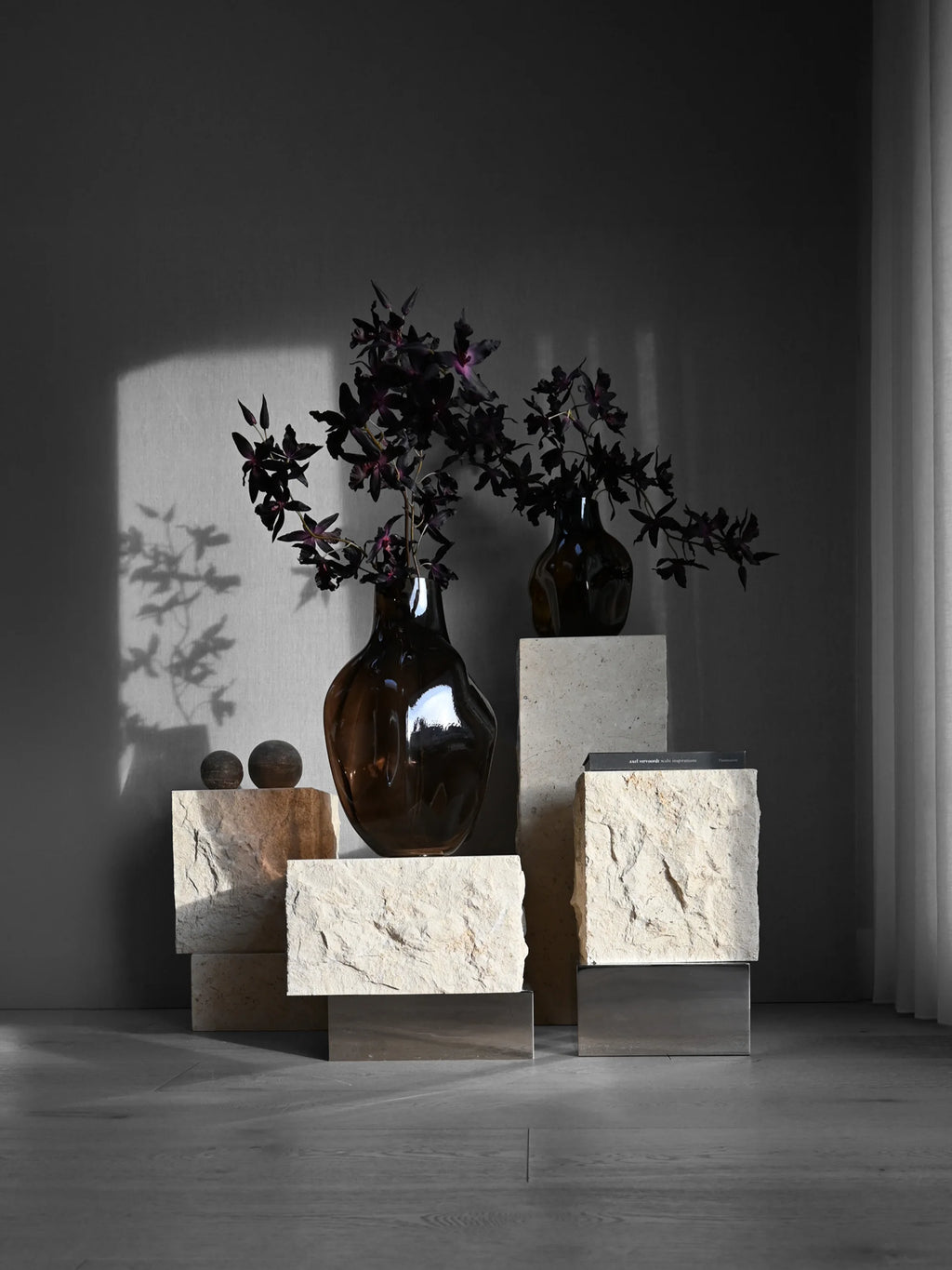 101 CPH Temple Coffee Table, a luxury modular design crafted from light beige and peach-toned chiseled travertine blocks, with polished chrome bases, displayed with dark brown glass vases and dark foliage in a minimalist setting. Perfect for a sophisticated living space.