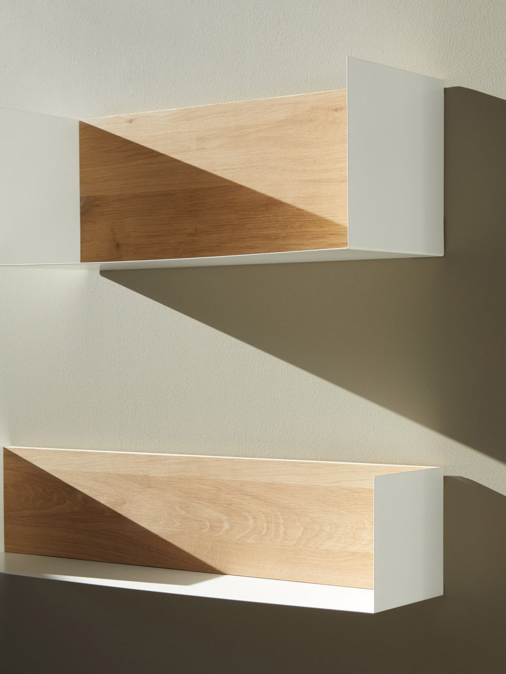 Ethnicraft U Shelf, a modern minimalist floating wall shelf featuring a natural solid oak front panel and a clean U-shaped white matte metal frame. This contemporary wall storage piece offers sleek lines, ideal for Scandinavian and modern interiors. Perfect for displaying decor in a living room, bedroom, or home office.
