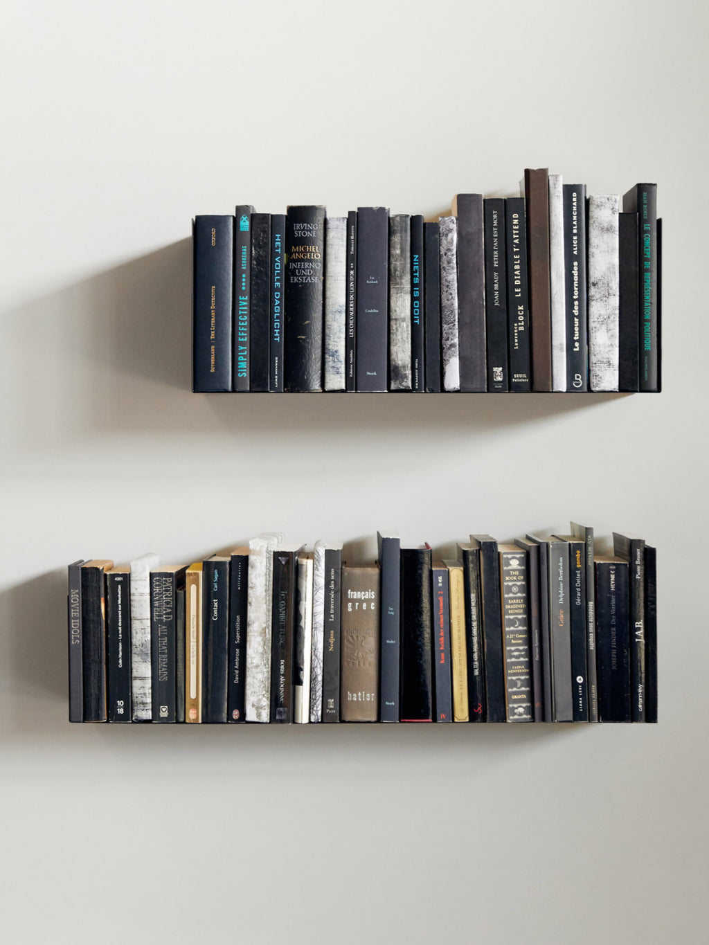 Ethnicraft U Shelf, a sleek modern minimalist floating shelf featuring a slender, almost invisible matte black profile that creates the illusion of books floating on the wall.