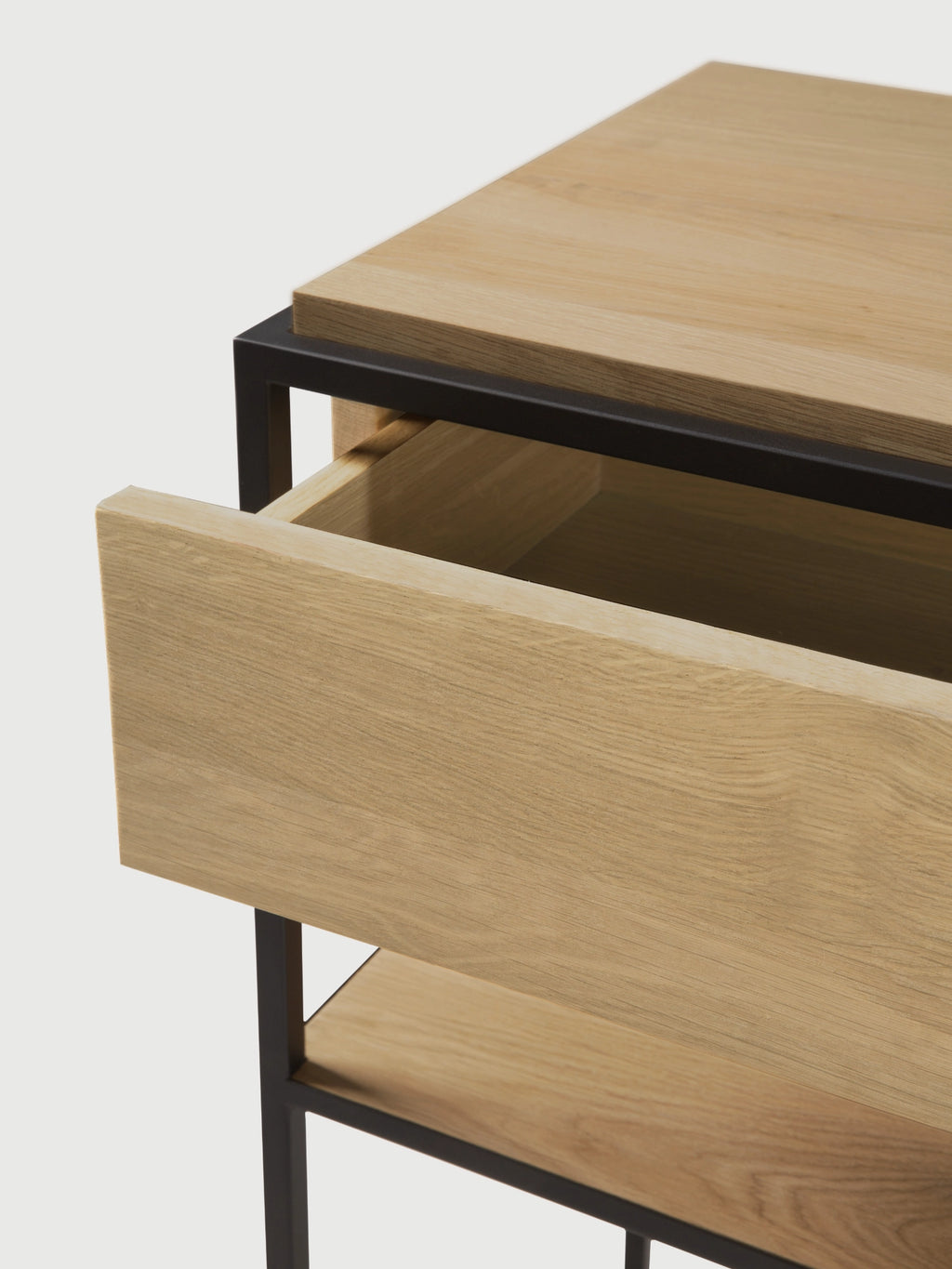 Ethnicraft Monolit Console, a modern minimalist console table crafted from natural solid oak with a clean-lined matte black metal frame, featuring a single smooth-gliding drawer and an open lower shelf. This versatile oak and metal console is ideal for a contemporary entryway, living room, or as a stylish bedroom accent.