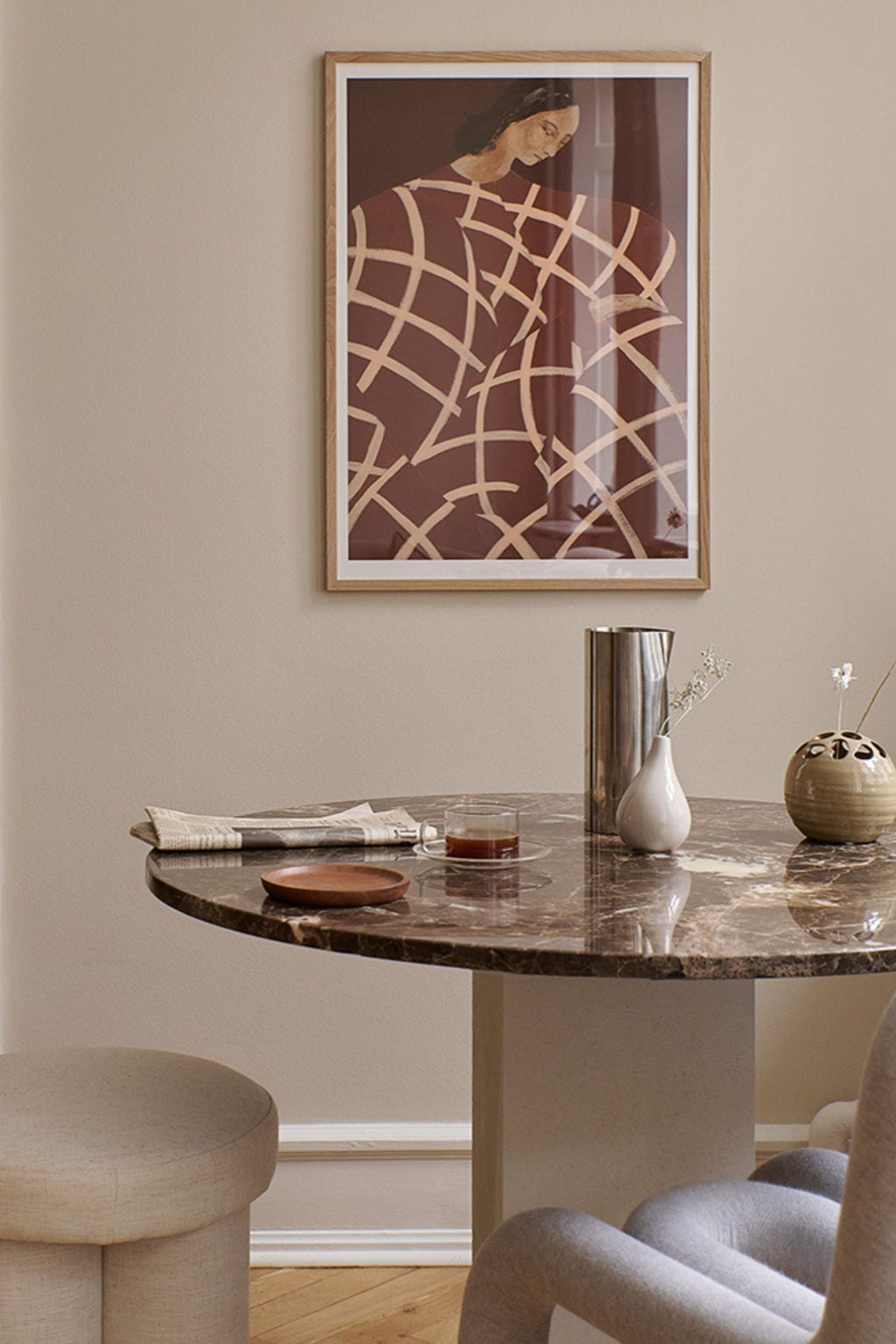 The Poster Club Waiting At Art Et Métiers, a contemporary abstract figurative art print featuring a rich brown background with a flowing light beige grid pattern, subtly depicting a draped figure. It's elegantly presented in a natural oak frame with a crisp white mat, offering a modern touch. Perfect as stylish wall art for contemporary gallery walls, modern living rooms, or minimalist bedroom decor.