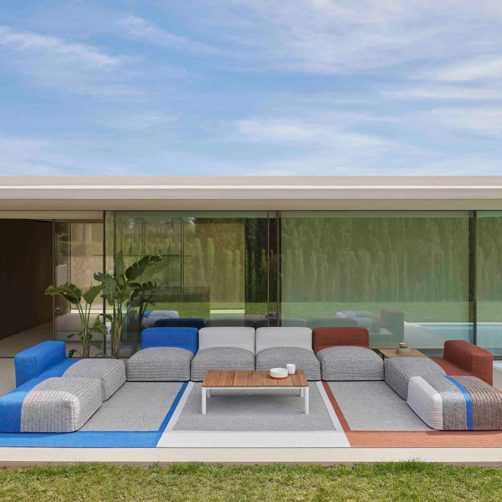 GAN Rugs Mangas Outdoor Composition 2, a vibrant modular outdoor sofa set featuring plush, textured woven outdoor fabric in a palette of bright blue, grey, white, and terracotta tones.