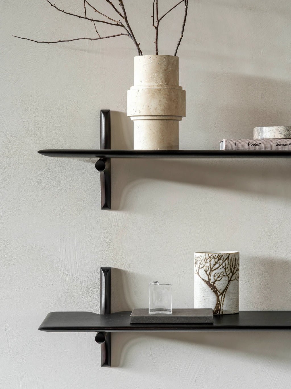 Ethnicraft PI Wall Shelf, a striking modern minimalist wall shelf featuring a sleek, dark stained solid wood construction with a smooth matte black finish and elegantly rounded edges. Its distinctive, sculptural supports seamlessly blend form and function, creating a contemporary floating shelf for sophisticated display. Ideal for organic modern living rooms, minimalist bedrooms, or stylish home office shelving.