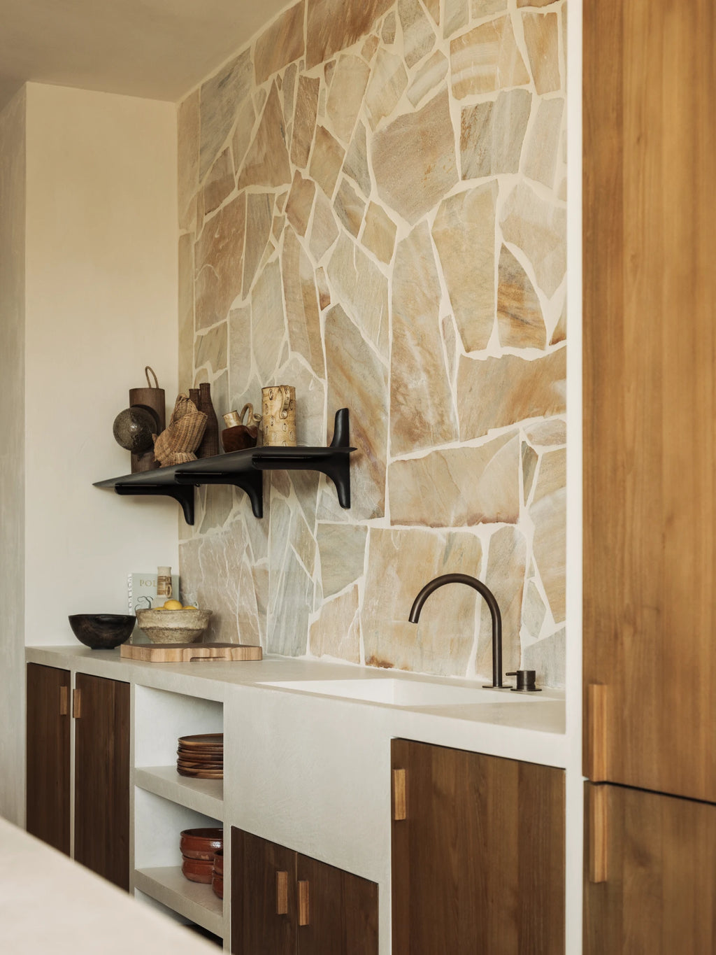 Ethnicraft PI Wall Shelf, a striking matte black sculptural wall shelf crafted from solid dark wood with a sleek, organic modern profile and integrated brackets. This contemporary floating shelf offers a minimalist display solution for curated objects. Perfect for brutalist or organic modern shelf styling in a kitchen, living room, or entryway.