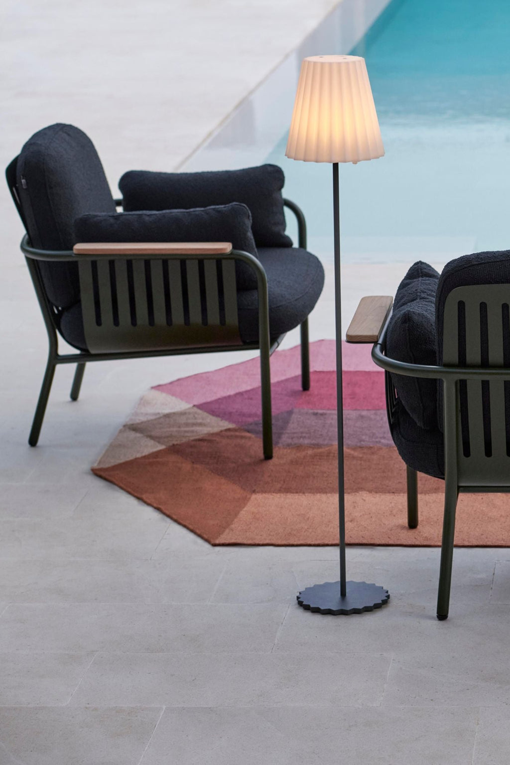 Gandia Blasco Capa 2-Seat Sofa, a modern outdoor sofa featuring a durable dark green powder-coated aluminum frame with sleek slatted sides and elegant natural wood armrests. It includes plush, deep-seated cushions upholstered in a textured dark charcoal outdoor fabric, providing comfortable and resilient lounge seating. Ideal for contemporary patio living rooms, poolside lounge areas, or minimalist garden settings.