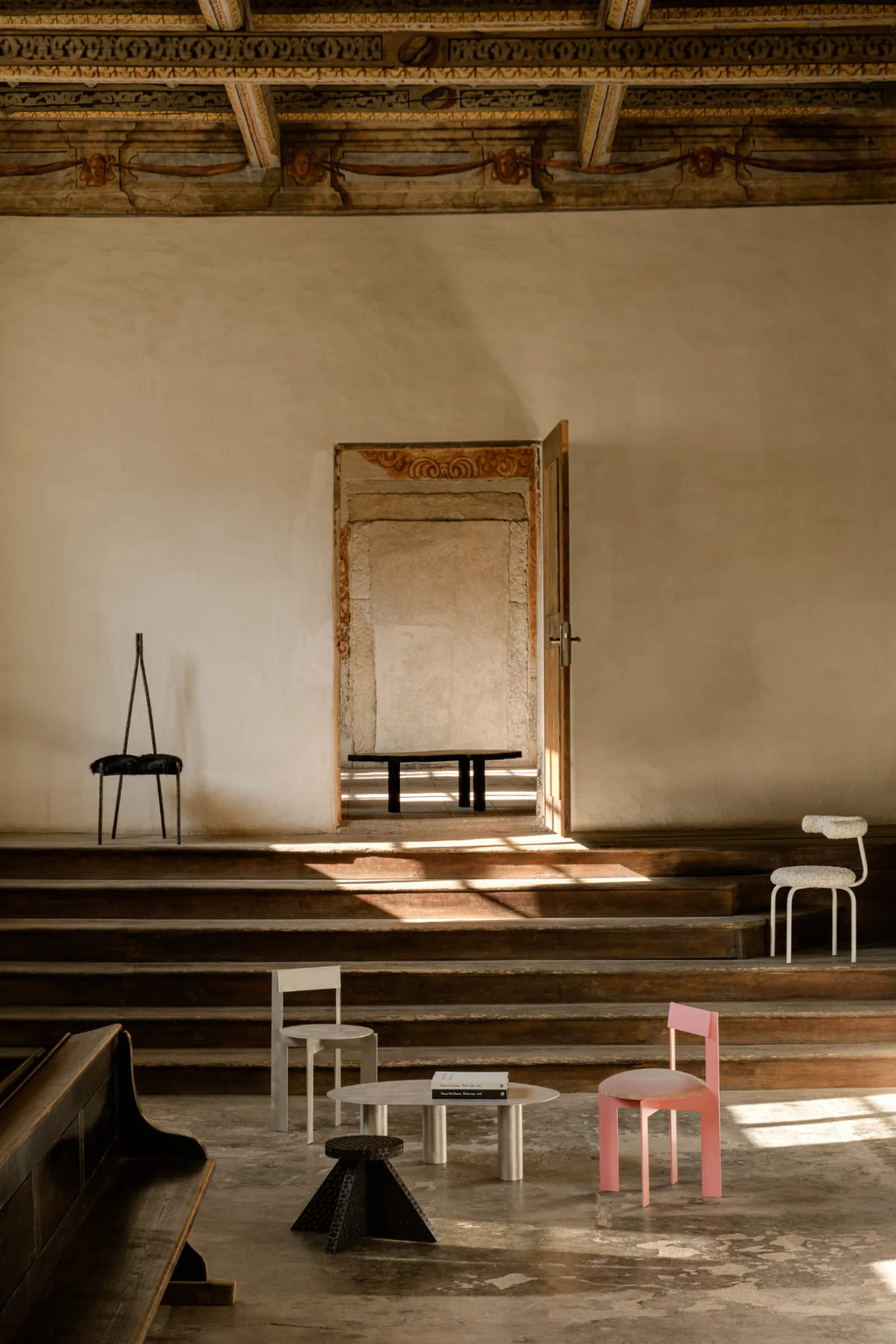 NG DESIGN Object 111 Chair, a modern light pink chair with a soft cushion, featured with other designer furniture in a historic, sunlit interior. Ideal for contemporary decor.