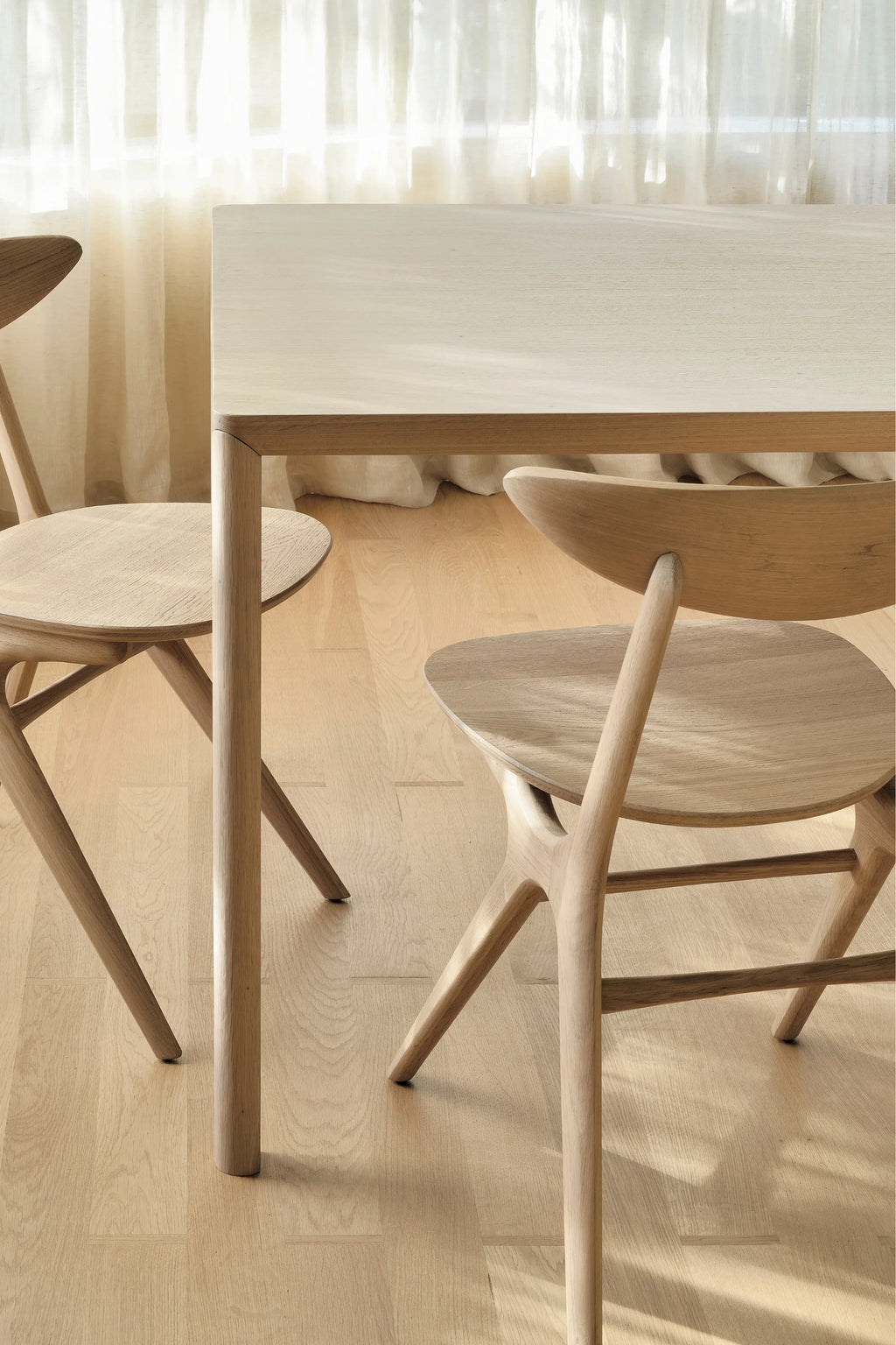 Ethnicraft Air Dining Table, a modern minimalist solid oak dining table with a light natural finish and clean, understated design. It features a rectangular tabletop and sturdy, rounded solid oak legs, showcasing the beautiful wood grain. Perfect for Scandinavian dining rooms, contemporary kitchen spaces, or organic modern interiors seeking a light wood aesthetic.