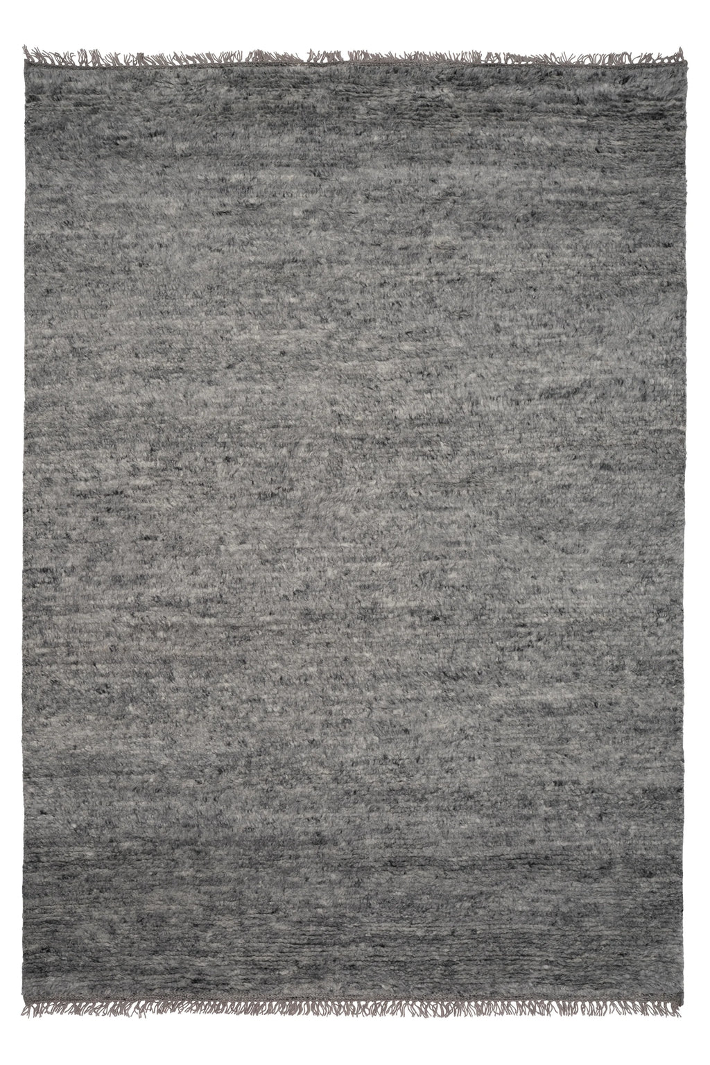 Linie Design Soft Savannah Wool Rug, a hand-knotted grey wool area rug featuring a plush, textured pile with subtle variations in charcoal and ash tones, creating an organic modern feel. This cozy rug includes delicate fringed ends, perfect for adding warmth to a Scandinavian living room, minimalist bedroom, or contemporary dining space.