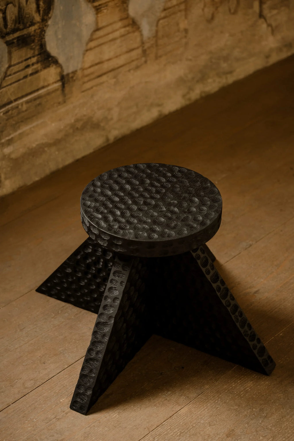 NG DESIGN Object 112 Side Table. Dark charcoal black wood with hammered texture across the round top and triangular legs. A premium accent piece.