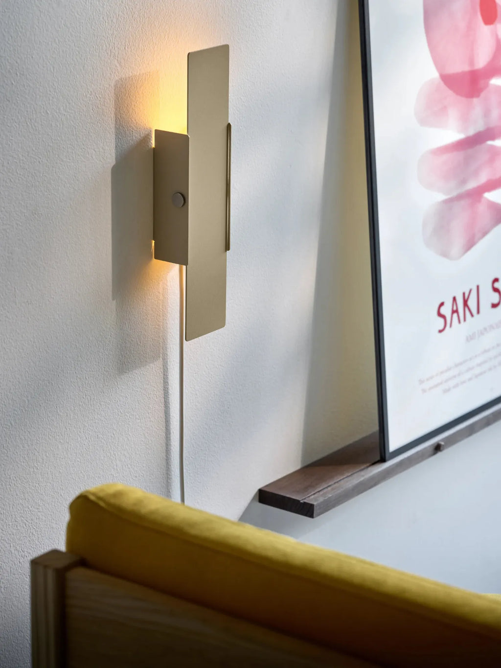 MOEBE Pivoting Wall Lamp, a modern minimalist wall light featuring overlapping rectangular panels of matte brushed brass metal that pivot to direct warm ambient illumination.