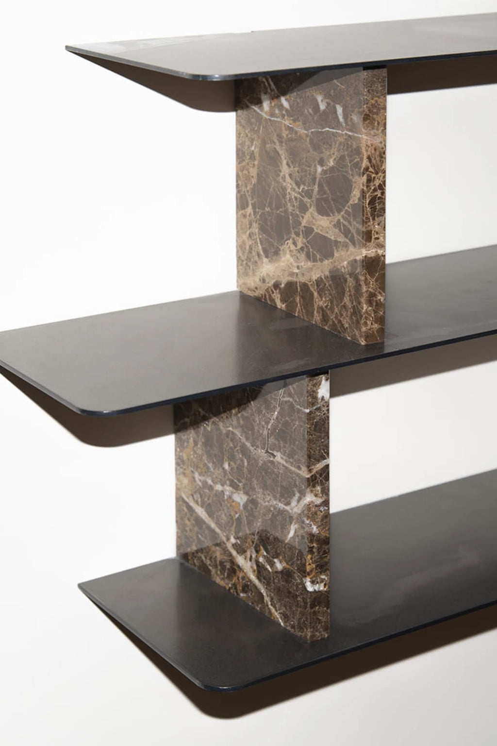 NG DESIGN Object 094 Shelf, featuring three sleek black metal shelves with rounded edges, supported by two luxurious dark brown marble risers with white and gold veining, against a white background. Ideal for a modern decor aesthetic.