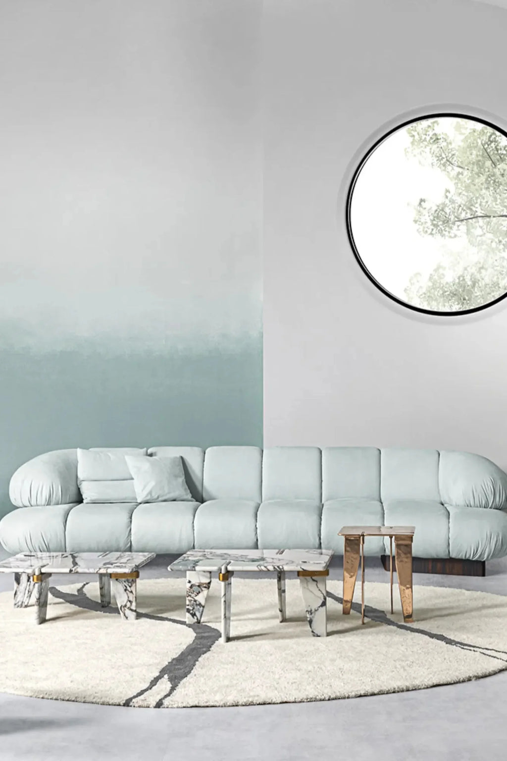 Hessentia Kiro Long Sofa, a contemporary organic modern sofa upholstered in a soft, pale aqua fabric with a plush, low-profile design. It features generous, rounded arms and backrests, creating an inviting, sculptural silhouette atop a dark wood base. Perfect for a spacious modern minimalist living room or a luxurious contemporary lounge space.