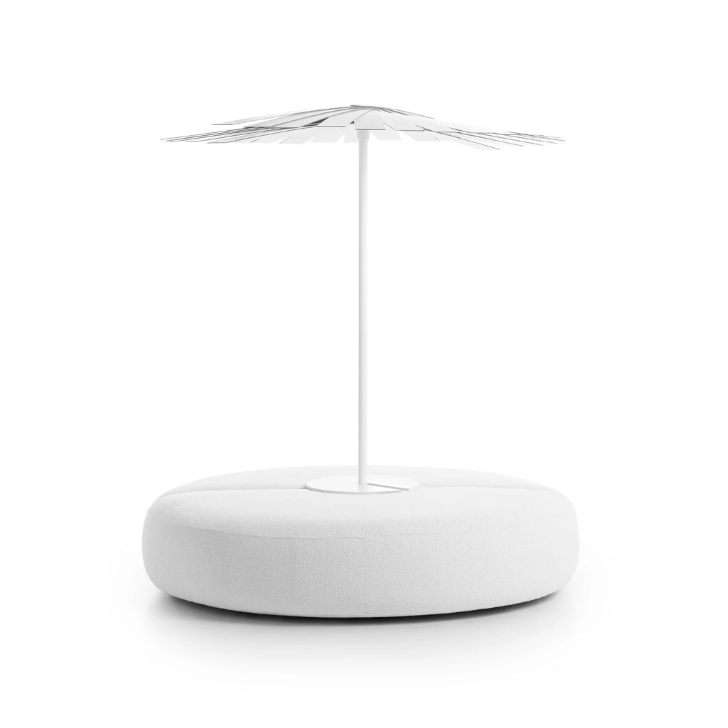 Gandia Blasco Ensombra Folding Parasol with Seating, a striking modern minimalist outdoor furniture piece featuring a round, plush white upholstered fabric ottoman base for comfortable lounging. Its integrated white metal folding parasol boasts a unique layered, petal-like slat design, providing elegant and adjustable shade.