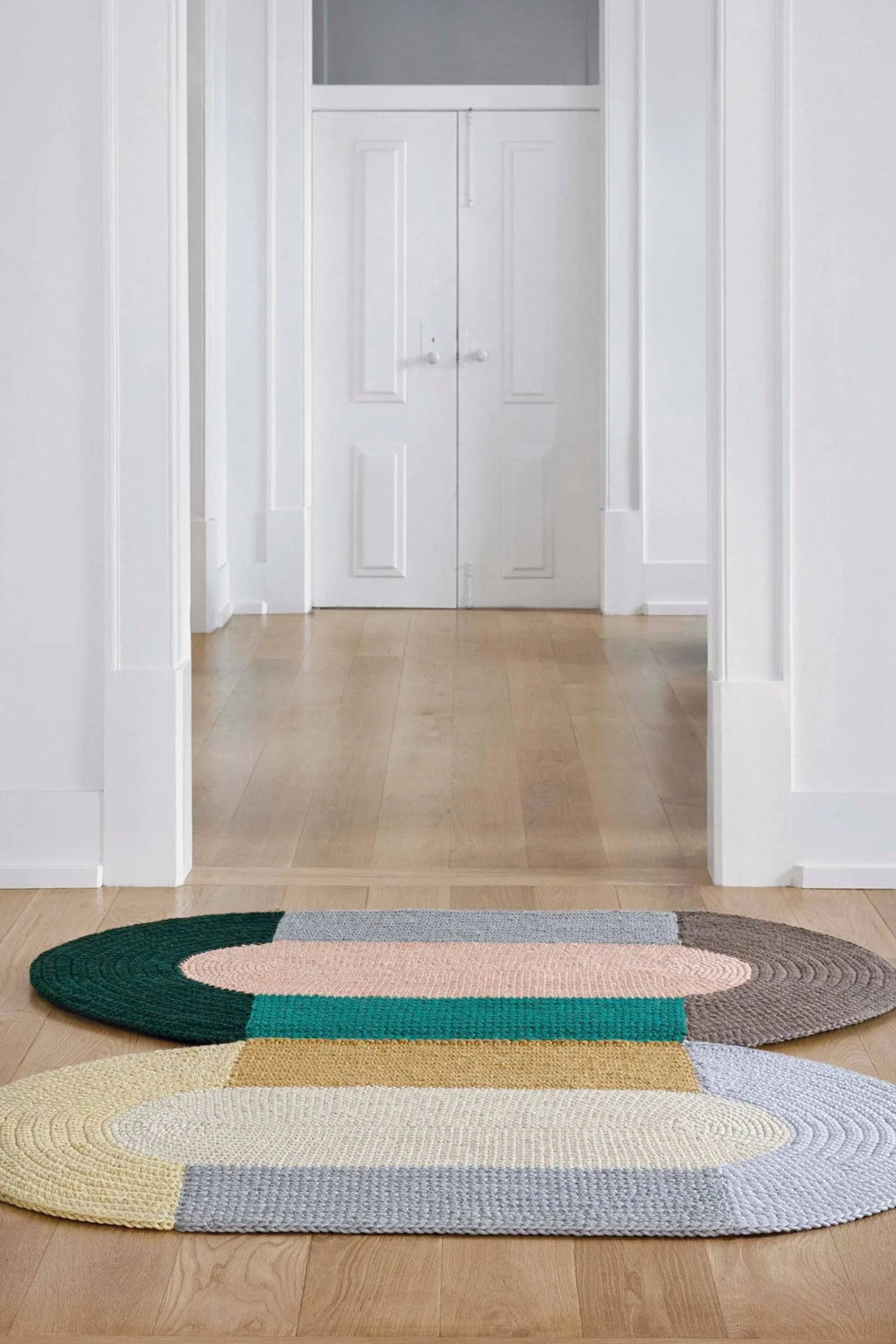 GAN Rugs Mono Beige Rug, a modern oval area rug featuring a braided chunky knit texture in a geometric color block design with muted tones of light yellow, off-white, light grey, and.