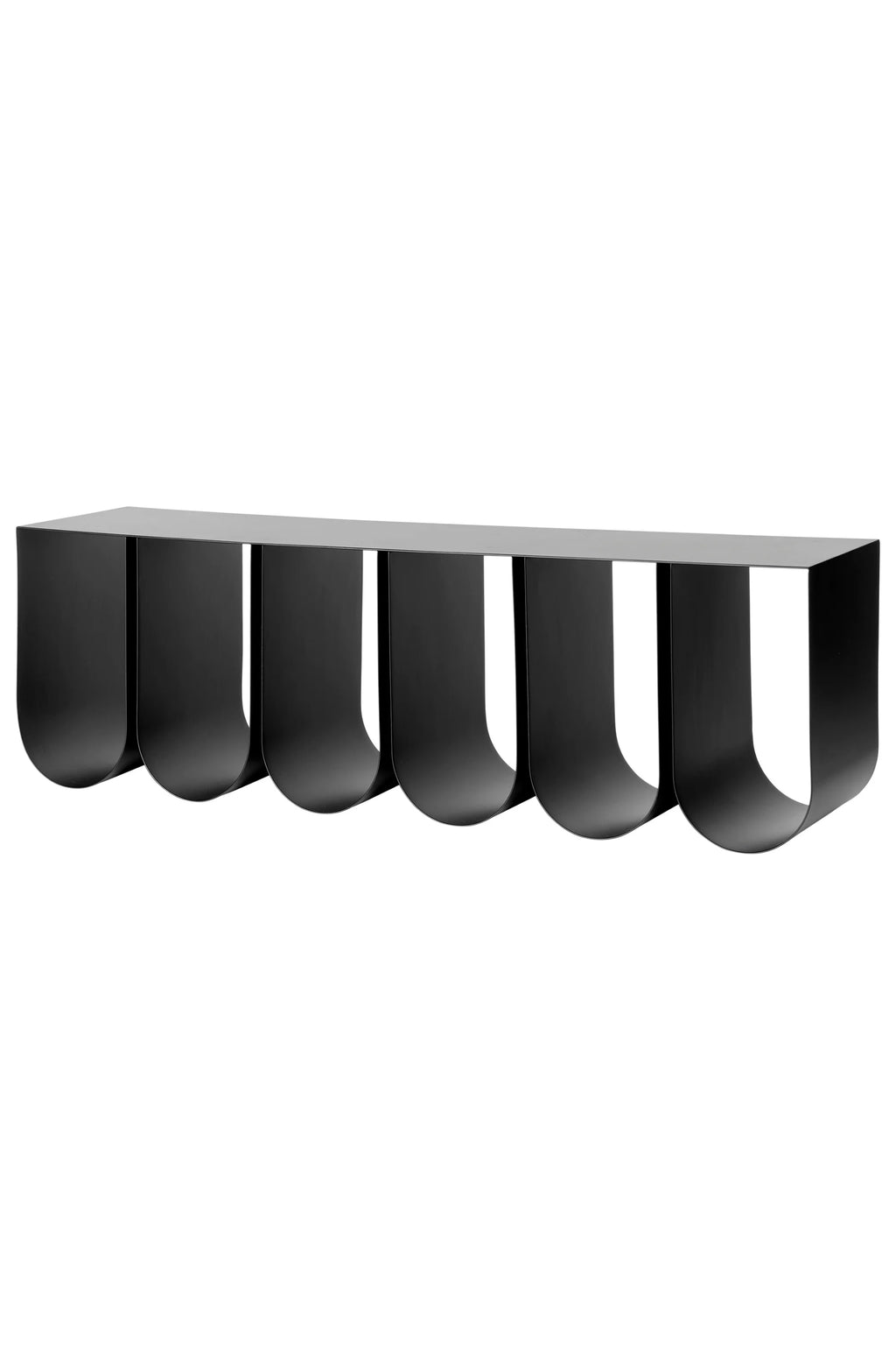 Kristina Dam Curved Wall Shelf, a modern minimalist floating shelf crafted from smooth matte black metal, featuring a distinctive sculptural design with a flat top surface supported by six inverted U-shaped curves.