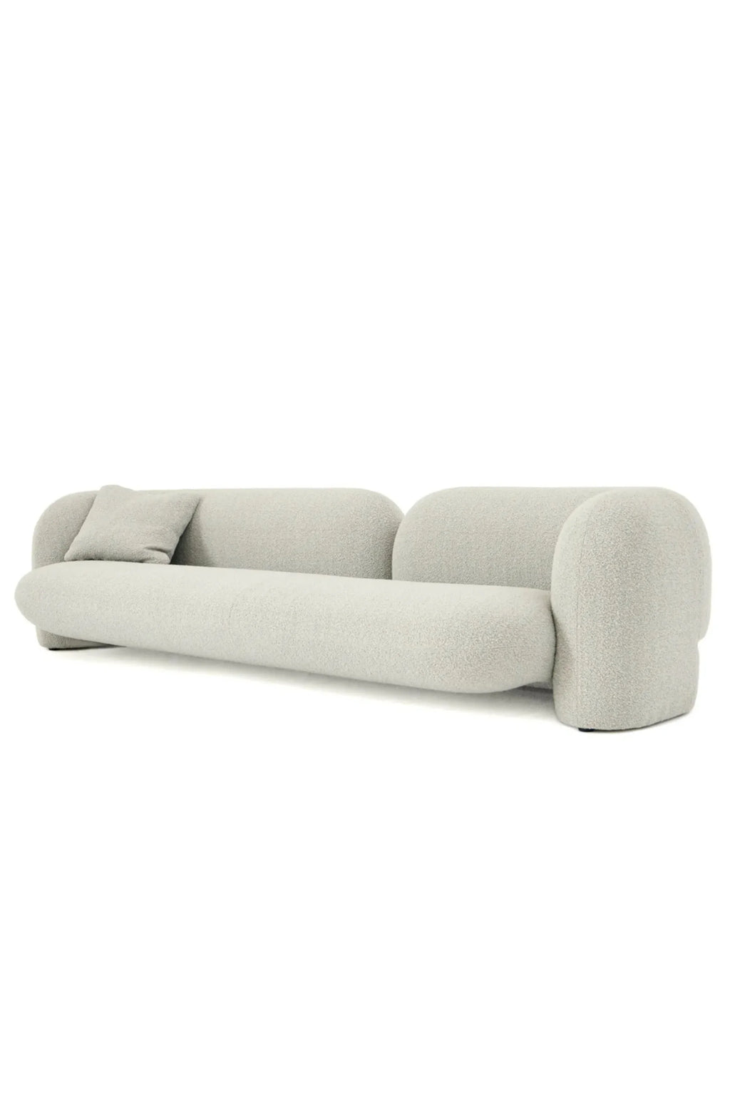Hessentia Gio Sofa, a contemporary organic modern sofa featuring a distinctive low-profile, cloud-like silhouette with softly rounded edges and a curved backrest, upholstered in a plush light grey bouclé fabric. This sculptural upholstered sofa includes a matching throw pillow, perfect for minimalist living rooms or luxurious lounge areas seeking a cozy yet chic aesthetic.