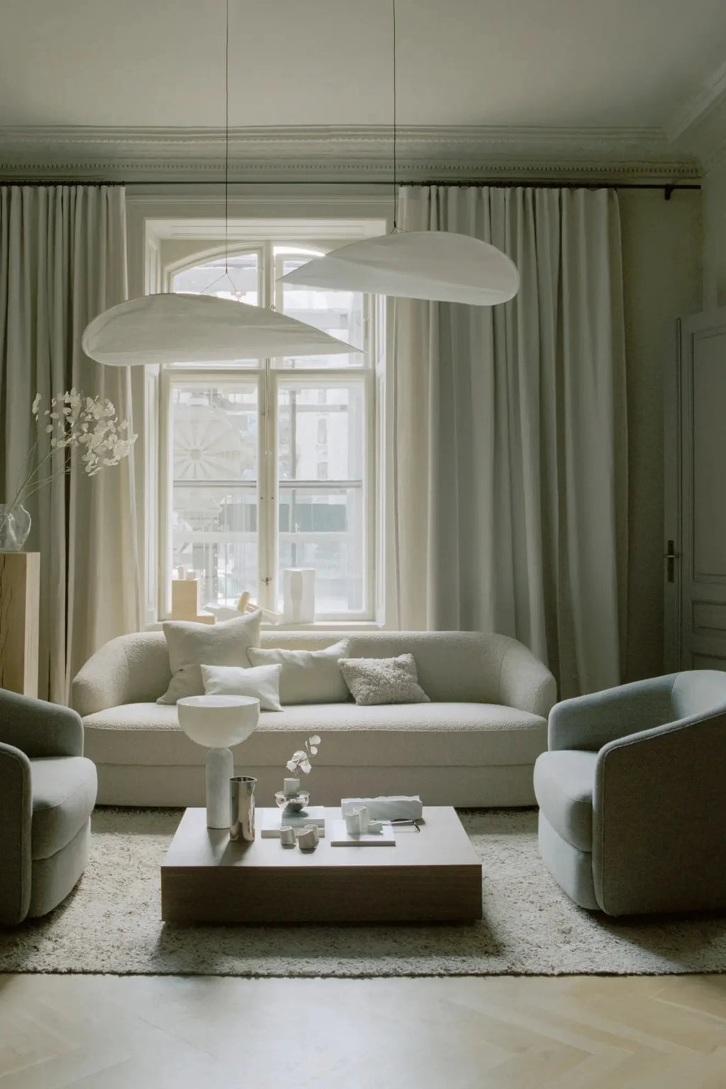 New Works Covent Sofa Deep 3-Seater, a luxurious organic modern sofa upholstered in plush cream bouclé fabric with a highly textured finish and inviting deep seating. Its gently curved silhouette and low-profile design create a minimalist aesthetic, perfect for contemporary living rooms and Scandinavian-inspired spaces.