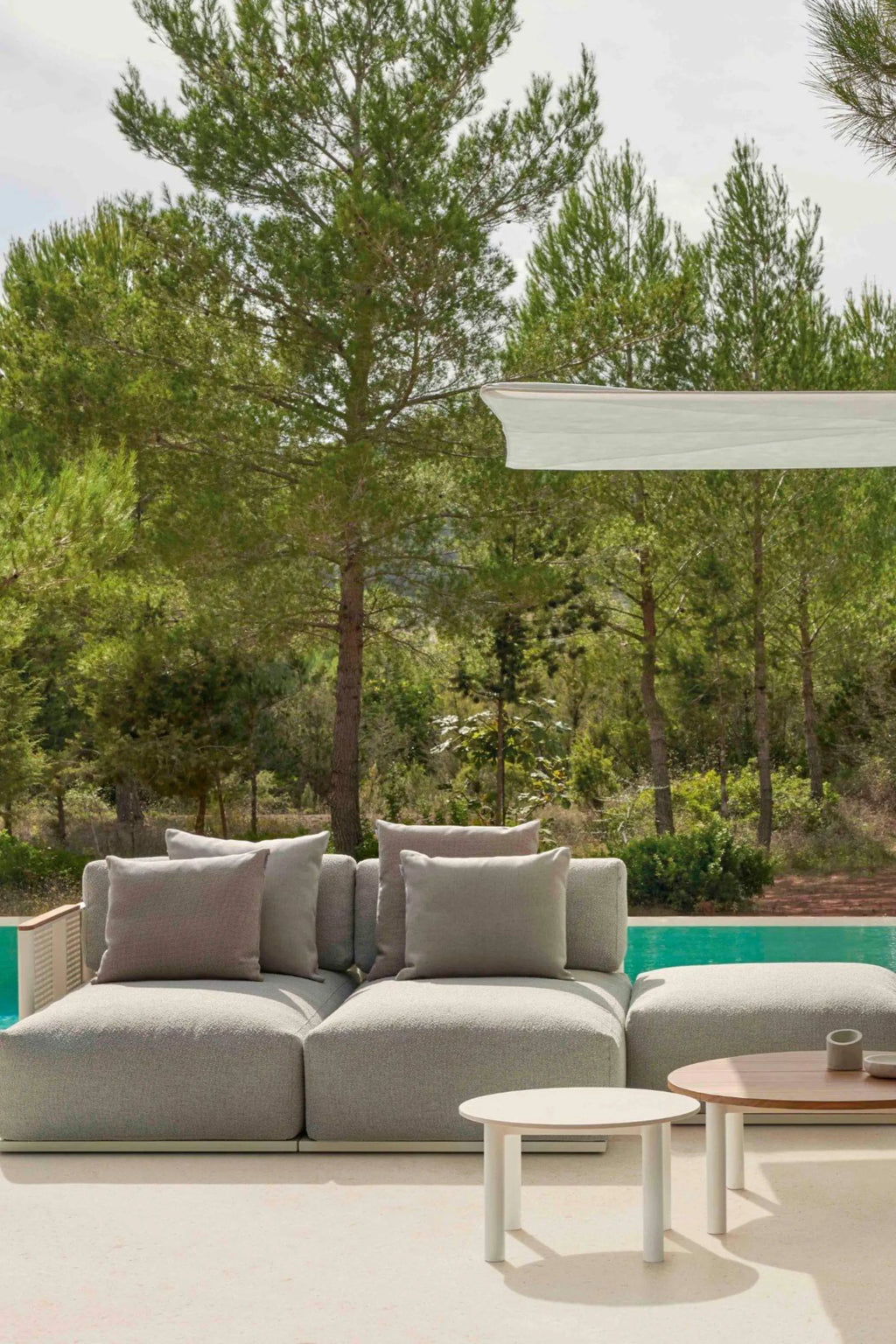 Gandia Blasco Bosc Sectional 6, a modern modular outdoor sectional sofa upholstered in a durable light grey textured fabric with plush taupe cushions and a distinct braided rope armrest detail. This low-profile contemporary patio lounge furniture is designed for ultimate comfort and style. Perfect for creating a luxurious poolside seating area or a minimalist outdoor living space.