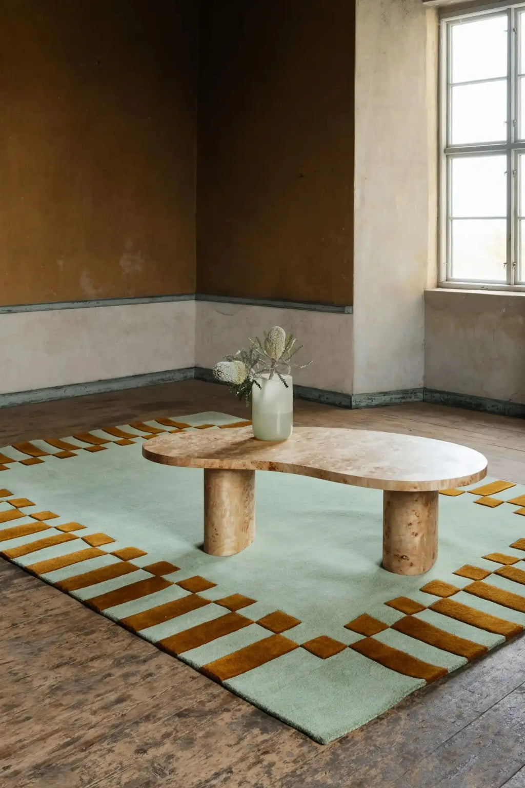 Layered Frame Wool Rug, a modern pale green and gold patterned area rug made from soft wool, featuring a geometric block design. Perfect for adding contemporary style and comfort to living spaces.