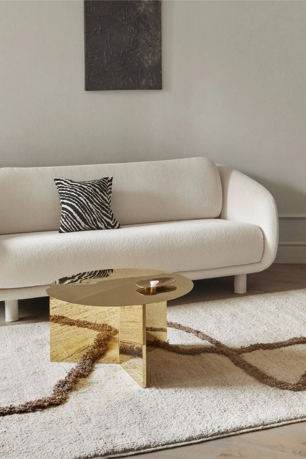 Sera Helsinki Vuoristo Rug, a hand-knotted wool area rug featuring a plush cream-colored base with a textured, organic brown abstract pattern. The natural undyed wool offers a soft, inviting feel and subtle variations in tone. Ideal as a cozy minimalist rug for Scandinavian living rooms or organic modern bedrooms.
