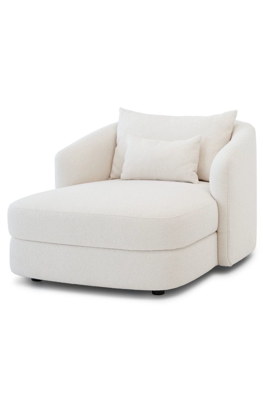 New Works Covent Chaise Lounge, a cream bouclé chaise lounge featuring a plush, textured fabric upholstery and a soft, organic curved silhouette with a single armrest. This contemporary lounge chair includes two matching throw pillows and offers a cozy, low-profile design. Ideal for modern minimalist living rooms, luxurious bedrooms, or comfortable reading nooks.