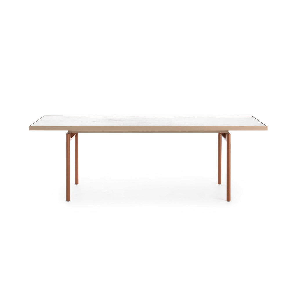 Gandia Blasco Onde Dining Table, a sleek rectangular modern outdoor dining table featuring a minimalist design. Its light grey composite or HPL top offers a durable, smooth surface, supported by striking slender copper-toned aluminum legs. This contemporary garden furniture piece is perfect for creating an elegant dining area on a patio, terrace, or in a modern backyard.