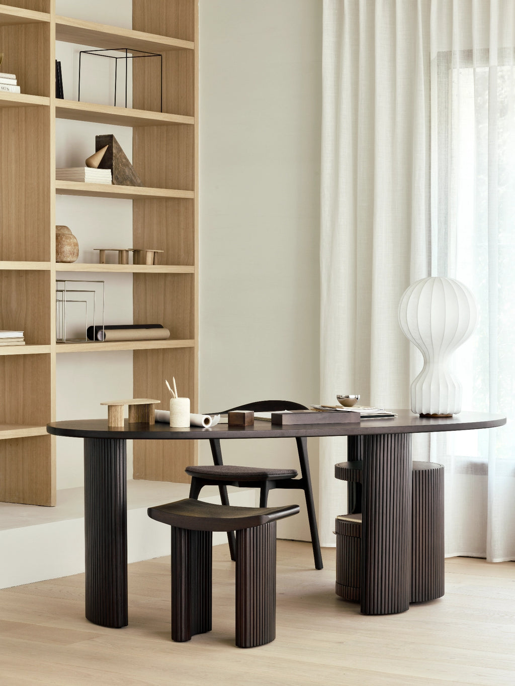 Ethnicraft Boomerang Drawer Unit, a sophisticated dark brown solid wood storage solution featuring a distinctive fluted cylindrical design and a subtly curved integrated drawer. This contemporary and organic modern piece, likely crafted from dark oak, adds minimalist elegance and practical storage to any home office or creative workspace.