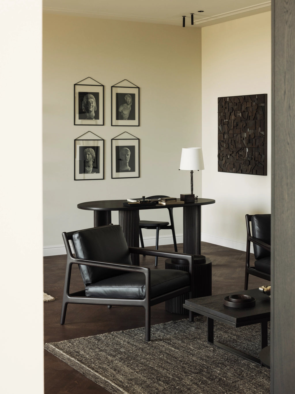 Ethnicraft Jack Lounge Chair, a modern minimalist lounge chair featuring a dark solid wood frame with clean lines, slightly angled legs, and wide armrests, upholstered in plush black leather cushions. This contemporary black armchair offers sophisticated comfort for living rooms, bedrooms, or refined home office spaces.