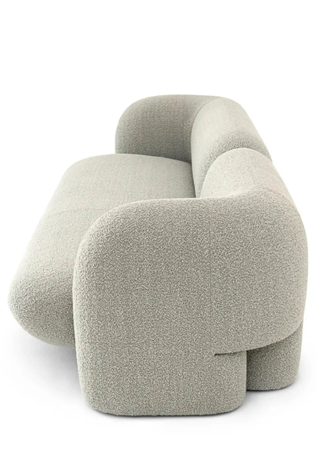 Hessentia Gio Sofa, a contemporary organic modern sofa featuring a unique sculptural and rounded profile, upholstered in a plush light grey bouclé fabric with a soft, textured finish.