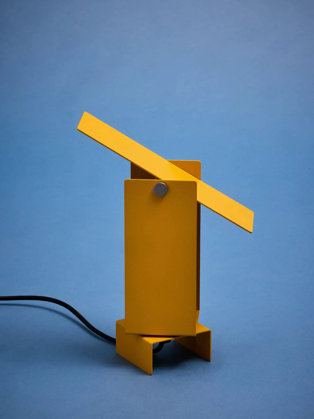 MOEBE Pivoting Table Lamp, a vibrant matte yellow powder-coated metal desk lamp featuring a minimalist geometric design with a rectangular base, body, and an adjustable pivoting light arm. This contemporary industrial-style lamp, with its functionalist aesthetic, offers directional lighting for modern home offices or creative studio spaces.
