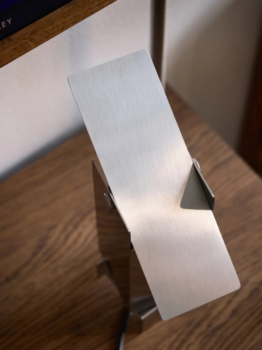 MOEBE Pivoting Table Lamp, a modern minimalist desk lamp crafted from brushed stainless steel with a sleek silver finish and a unique pivoting rectangular light panel. Its industrial chic design offers adjustable lighting for a contemporary home office or Scandinavian-inspired living room.