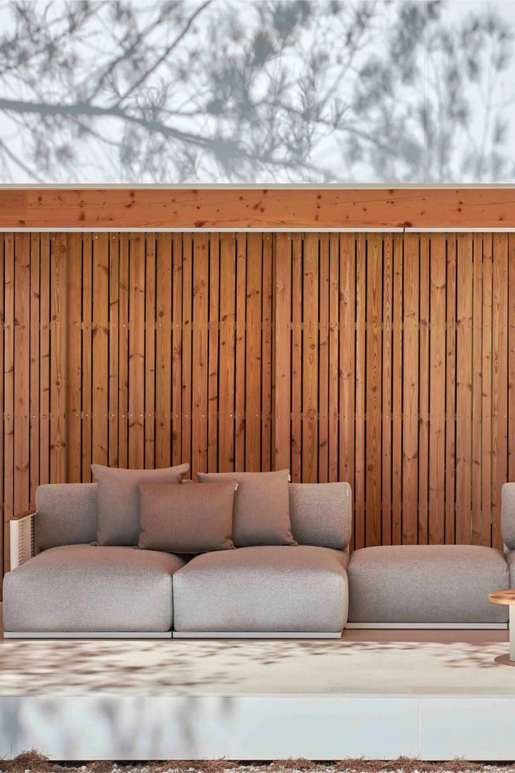 Gandia Blasco Bosc Sectional 6, a modern modular outdoor sofa featuring plush cushions upholstered in a light grey textured outdoor fabric, resting on a durable white aluminum frame with clean, low-profile lines and a natural wood armrest detail. This contemporary outdoor lounge seating is ideal for creating a sophisticated outdoor living room or stylish patio retreat.