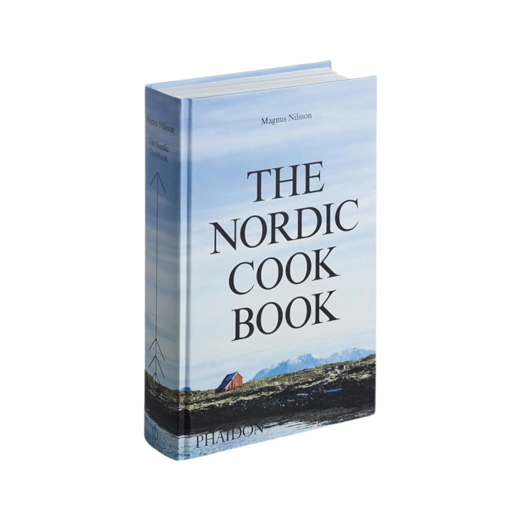  Two hands holding open The Nordic Cook Book with images of Nordic landscapes and traditional foods